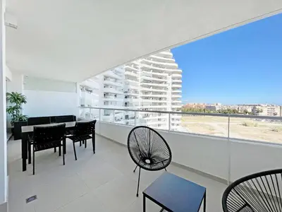 a living room with a table and chairs and a large window at Global Vacacional, Apartamento para 5 personas con terraza in Canet de Berenguer
