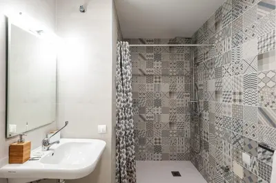 a white bathroom with a sink and a mirror at El Mosaico Apartment in Valencia