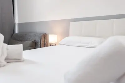a bedroom with two beds and a chair at El Mosaico Apartment in Valencia