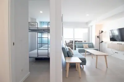 a living room with a couch and a bunk bed at Global Vacacional, Apartamento con terraza y vistas a la costa mediterránea in Canet de Berenguer
