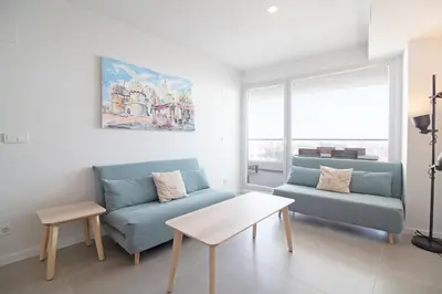 a living room with two blue couches and a table at Global Vacacional, Apartamento con terraza y vistas a la costa mediterránea in Canet de Berenguer