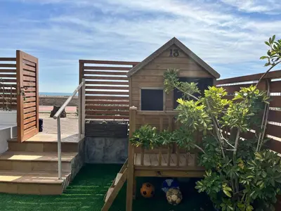 a wooden house with a staircase and a garden at Casa en primera linea de playa in Puzol