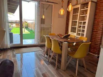 a dining room with a wooden table and yellow chairs at Casa en primera linea de playa in Puzol