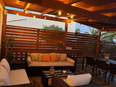 a patio with a couch and chairs and a table at Casa en primera linea de playa in Puzol