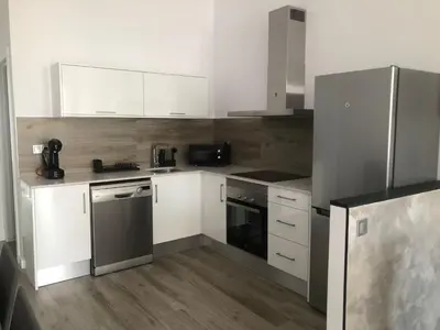 a kitchen with white cabinets and a stainless steel refrigerator at Urban Beach in Valencia