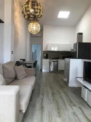 a living room with a couch and a kitchen at Urban Beach in Valencia