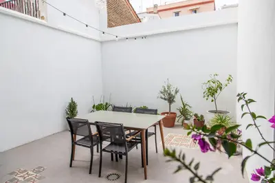 a patio with a table and chairs and potted plants at Maritime House Valencia Beach in Valencia