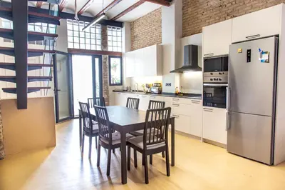 a kitchen with a table and chairs and a refrigerator at Maritime House Valencia Beach in Valencia