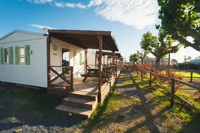a tiny house with a porch and a fence at HolaCamp Chilches in Xilxes