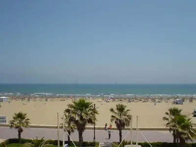 a beach with palm trees and people on it at Villa near Valencia with Private Pool in Valencia