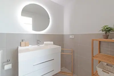 a bathroom with a white sink and a mirror at Global Vacacional, Apartamento con amplia terraza con vistas al mar in Canet de Berenguer