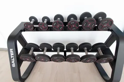 a black rack filled with dumbbells on a floor at Global Vacacional, Apartamento con amplia terraza con vistas al mar in Canet de Berenguer