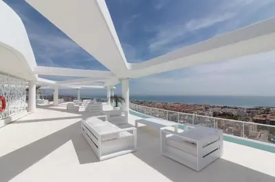 a balcony with white chairs and a view of the ocean at Global Vacacional, Apartamento con amplia terraza con vistas al mar in Canet de Berenguer
