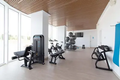 a gym with treadmills and exercise equipment in a room at Global Vacacional, Apartamento con amplia terraza con vistas al mar in Canet de Berenguer