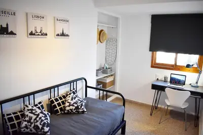 a bedroom with a bed and a desk with a laptop at Departamento céntrico para disfrutar en familia in Sagunto