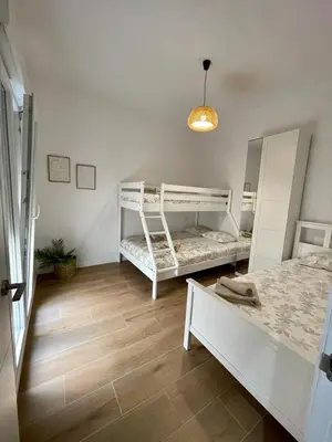 a bedroom with two bunk beds and a lamp at UIM Mediterraneo CASA Sepulveda Wifi in Puerto de Sagunto