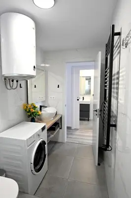 a white bathroom with a washing machine in it at Victoria Apartment in Puerto de Sagunto