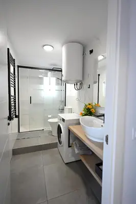 a bathroom with two sinks and a toilet and a shower at Victoria Apartment in Puerto de Sagunto