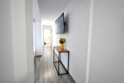 a hallway with a table with a vase of flowers on it at Victoria Apartment in Puerto de Sagunto
