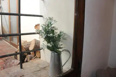 a vase with flowers in it next to a window at Alojamiento turistico LaVid in Requena