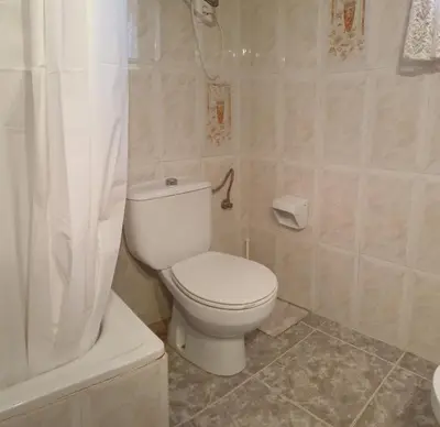 a bathroom with a white toilet and a shower at Vacansis Habitaciones Privada en una Villa a un paso del Mar en Cullera in Cullera