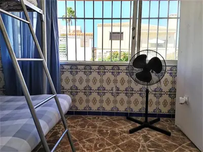 a room with a bunk bed and a fan and a window at Vacansis Habitaciones Privada en una Villa a un paso del Mar en Cullera in Cullera