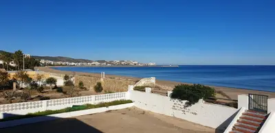 a view of a beach with a white fence and the ocean at Vacansis Habitaciones Privada en una Villa a un paso del Mar en Cullera in Cullera