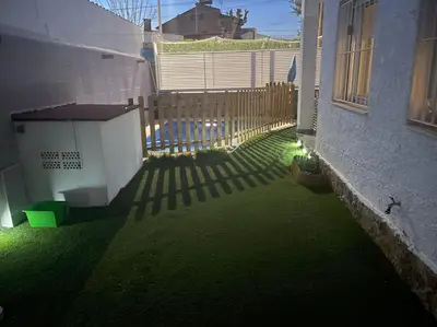 a backyard with a fence and green grass at Chalet Antonio&Ewa in La Eliana
