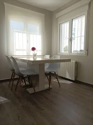 a dining room with a table and chairs and windows at Chalet Antonio&Ewa in La Eliana