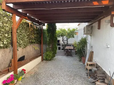 an outdoor patio with a wooden pergola and plants at Chalet Antonio&Ewa in La Eliana
