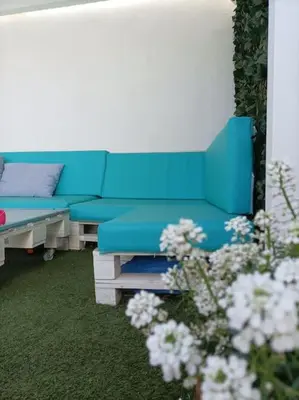 a blue couch in a living room with flowers at Chalet Antonio&Ewa in La Eliana