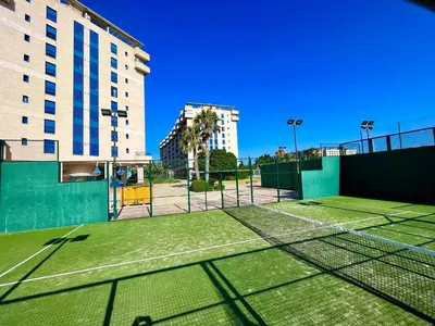 a tennis court in front of a building at Blue Beach Apartment+Oceanview+Private Parking in Valencia