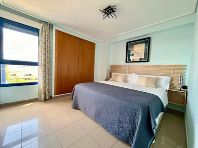 a bedroom with a large bed and a window at Blue Beach Apartment+Oceanview+Private Parking in Valencia