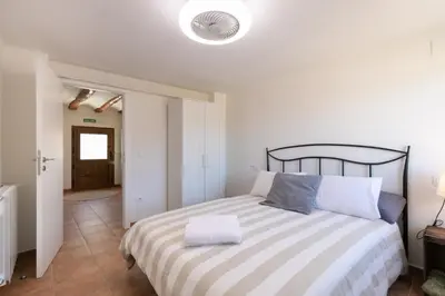 a bedroom with a large bed with a striped blanket at Casa Rural Lavadero en Teresa in Ríos de Abajo