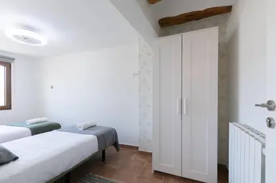 a bedroom with two beds and a closet at Casa Rural Lavadero en Teresa in Ríos de Abajo