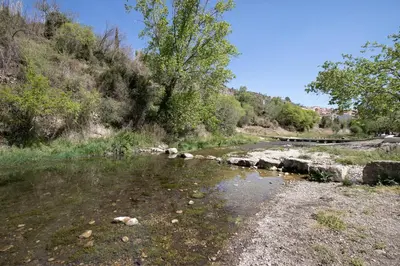 a river with rocks on the side of a road at Casa Rural Lavadero en Teresa in Ríos de Abajo