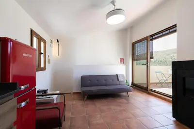 a living room with a couch and a tv at Casa Rural Lavadero en Teresa in Ríos de Abajo
