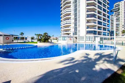 a large swimming pool in front of a tall building at ESPACIO 15 - Primera Línea de Playa in Cullera
