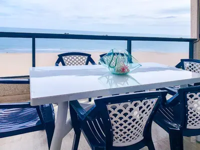 a white table and chairs with a view of the beach at ESPACIO 8 - Primera Línea de Playa in Cullera