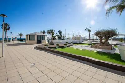 a park with palm trees and a building at ESPACIO 8 - Primera Línea de Playa in Cullera