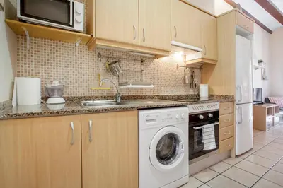a kitchen with a washing machine and a sink at Zerka Ayuntamiento in Valencia