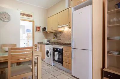 a kitchen with a white refrigerator and a table at Zerka Ayuntamiento in Valencia