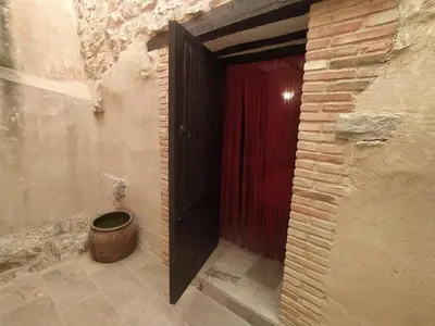 a room with a door and a barrel next to a red curtain at Casa Rural Mirador de la Torre in Alcublas