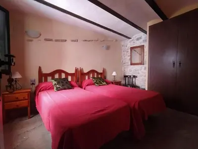 a bedroom with a large bed with a red blanket at Casa Rural Mirador de la Torre in Alcublas