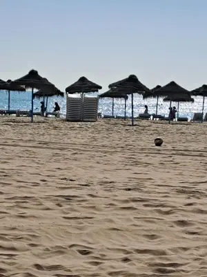a beach with umbrellas and people on the beach at 3 bedroom Flat with WiFi in Valencia