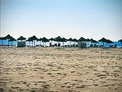 a group of umbrellas and chairs on a beach at 3 bedroom Flat with WiFi in Valencia