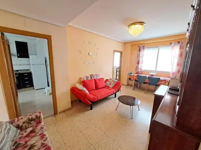 a living room with a red couch and a table at 3 bedroom Flat with WiFi in Valencia