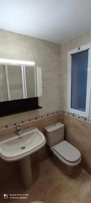 a bathroom with a sink and a toilet and a mirror at Mi pequeña terraza in Alaquas