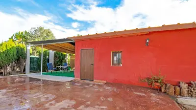 a red house with a red wall and a patio at Orange Blossom Finca Unique in Valencia