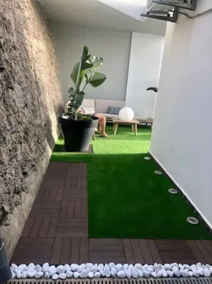 a room with a green floor and a plant at Racó de la Mar in Faro de Cullera